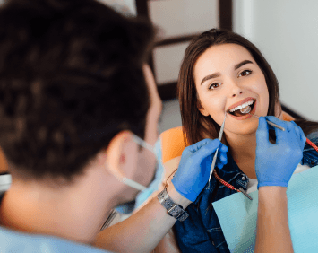 photo-back-professional-dentist-man-working-with-patient-modern-clinic 1