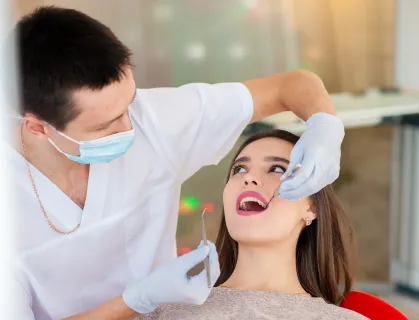 dentist-is-treating-teeth-with-beautiful-girl 2